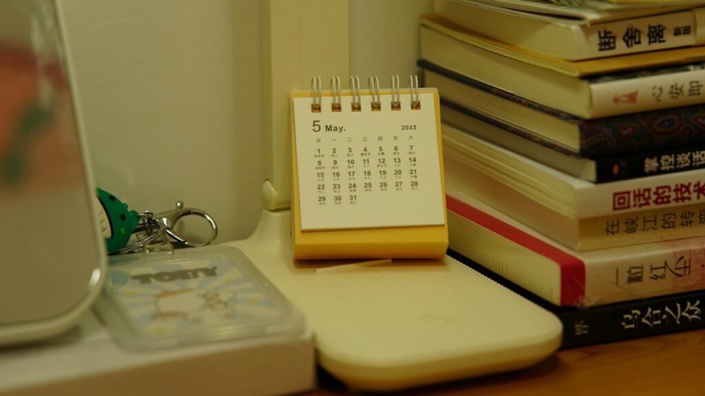 Small desktop calendar alongside books, illustrating planning ahead for subscription renewals